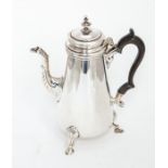 An Edwardian silver plain tapering cylindrical coffee pot, raised on three shell and hoof feet,