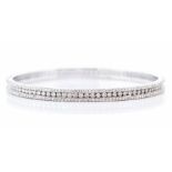 A diamond set 18ct white gold bangle, comprising a central channel set row of brilliant cut
