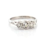 A diamond and platinum three-stone ring, diamond set shoulders, total diamond weight approx 0.95cts,