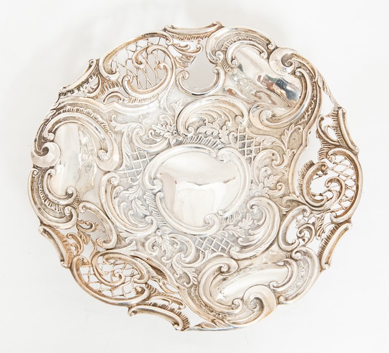 A Victorian silver circular fruit bowl, chased with scrolling foliage and openwork design, on raised