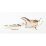 A group of George V silver including: a large oval sauce boat, scallop edge on three scroll feet, by
