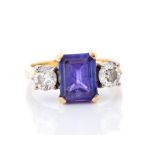 A tanzanite and diamond three-stone 18ct gold ring, the claw set rectangular cut tanzanite approx