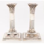 A pair of late Victorian silver Corinthian column candlesticks, garland decoration to base,