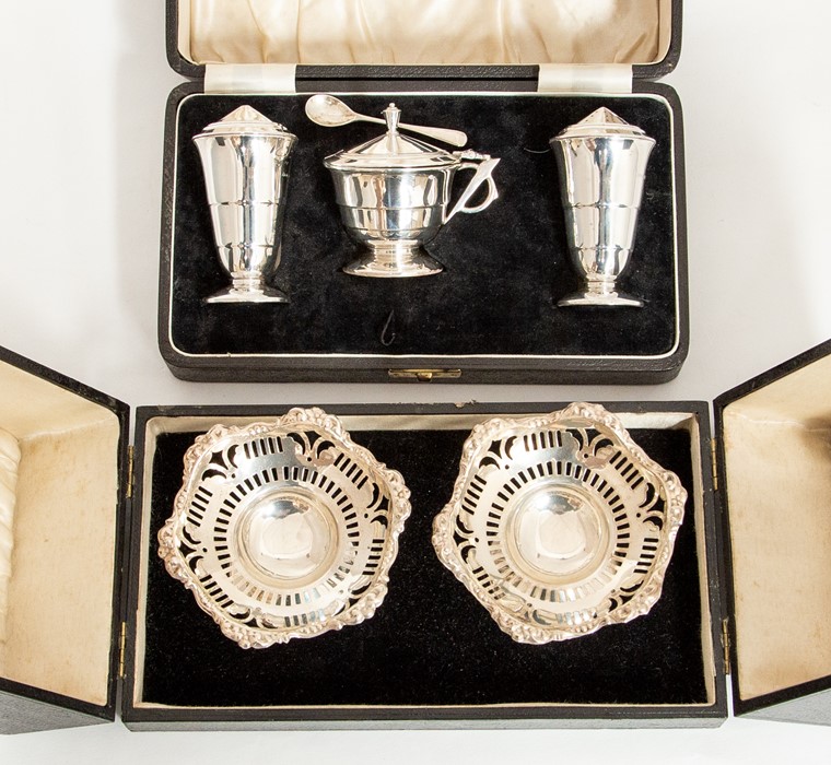 A matched pair of early 20th Century silver reticulated bon bon dishes on stands, wavy rim, by S