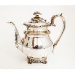 A George IV silver baluster shaped teapot, the apron cast with scrolling shells and foliage, above