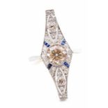 An Art Deco style diamond and sapphire ring, comprising a central brilliant cut champagne diamond