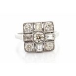 A diamond and platinum square cluster ring, set with five round brilliant-cut diamonds and four