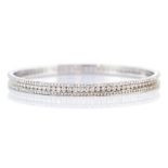 A diamond set 18ct white gold bangle, comprising a central channel set row of brilliant cut