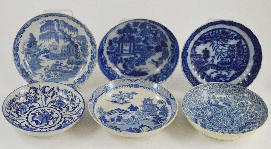 A collection of six early nineteenth century blue and white transfer printed saucers decorated