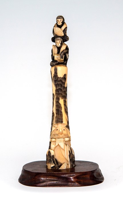 A Japanese ivory tusk carving, Meiji period, 1868-1912, carved as a bearded man playing a flute with