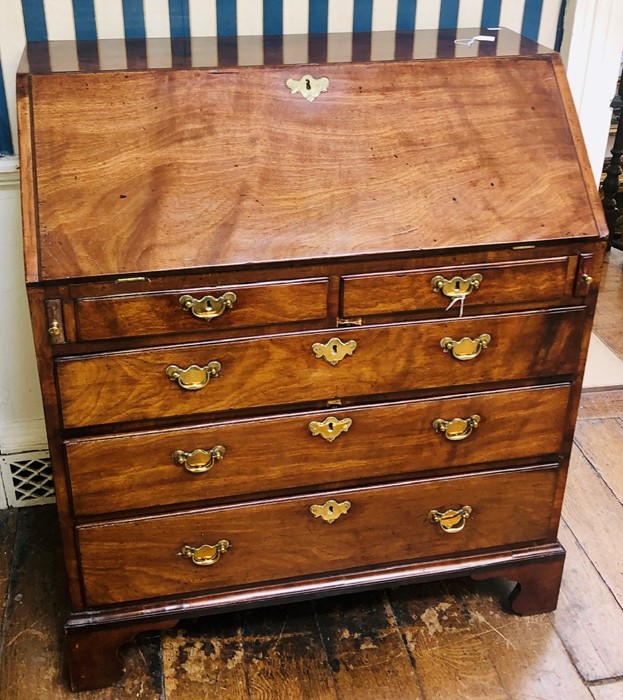 A George III mahogany bureau, circa 1820, fall front enclosing pigeon holes, small drawers and