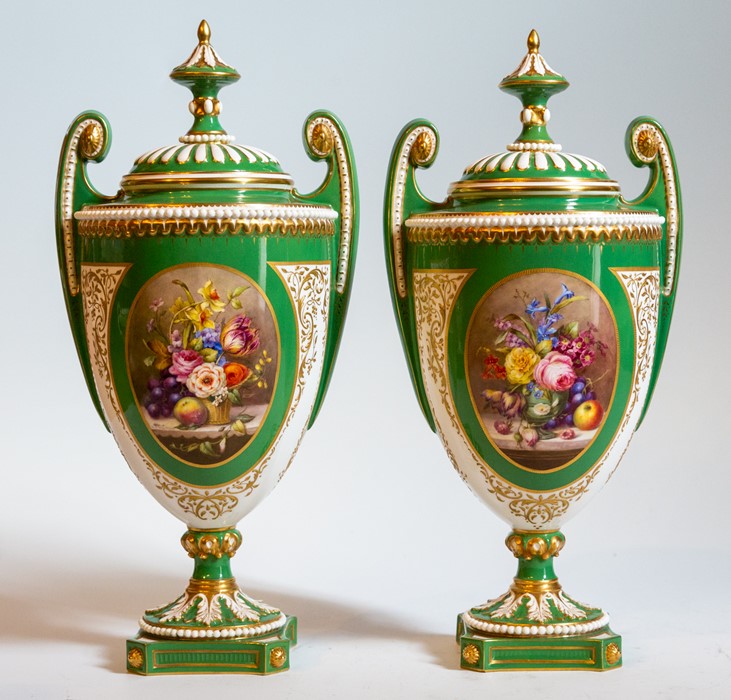 A pair of Royal Worcester vases and covers, Edwardian, on a green ground, central panel depicting