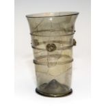 A tall green glass beaker with tooled trailed decoration and applied prunts, German, circa 1520,