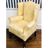 An early 20th Century mahogany framed and yellow damask later upholstered wingback armchair,