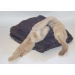 A 1950s (early) dark brown squirrel stole and a cream albino mink stole. (2)