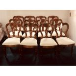 A set of twelve Victorian revival mahogany spoon back dining chairs, raised on turned supports. (