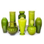 A group of Bretby art pottery green glazed vases in various forms including ovoid, cylindrical and