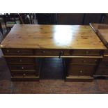 A 20th Century pine pedestal desk with brass handles.