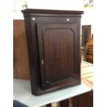 A 19th Century oak hanging corner cabinet, fitted with a single door