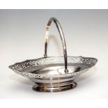 A George III boat shaped silver swing handled basket, scroll pierced border, bright cut engraved and