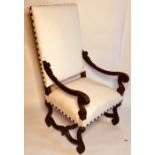 A Louis XIV revival French oak armchair, padded rectangular back with brass studs around the edge,