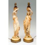 A pair of Royal Worcester blush ivory figural table lamps, in the form of a woman with two vases,