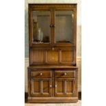 An Ercol elm glazed bookcase on sideboard, moulded cornice, three tier bookcase stored in two glazed