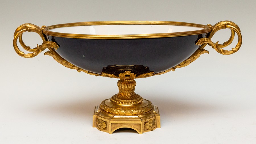 An late 19th Century pedestal centre bowl, two handled form, cobalt blue porcelain, ormolu handles