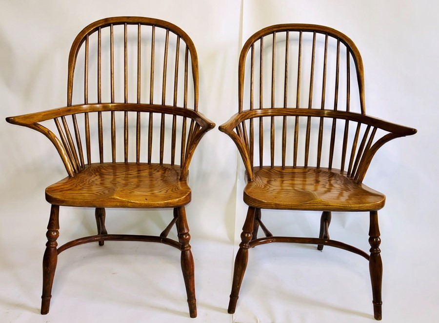 A pair of 19th Century elm and ash Windsor arm chairs, hooped back with curved arm rail on shepherds