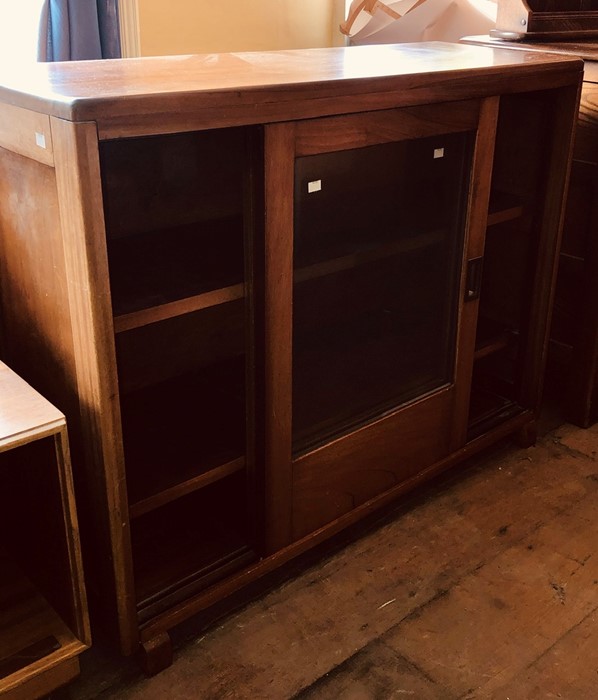 A 1970s teak framed bookcase, fitted with two glazed sliding doors