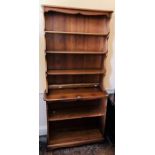 An Ercol elm freestanding open bookcase, of two-tier form, the upper section with three shelves, the
