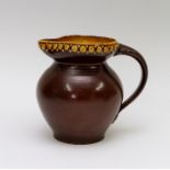 An early twentieth century Braunton Peasant Pottery studio art pottery handled jug, circa 1920-40.