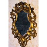 An early 18th century giltwood carved rococo design mirror, circa 1710, scrolling foliate and floral