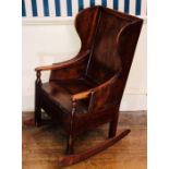 A 19th century fruitwood and mahogany child's rocking lambing chair, panelled back, boarded seat.