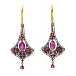 A pair of ruby drop earrings, comprising  suspended rub-over oval cut rubies to the centre, approx