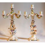 A pair of Meissen figural candelabrum, each with a central sconce and three branches, encrusted with