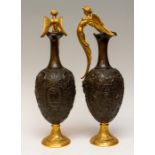 A pair of Bronze and gilt ewers, late 19th Century, each with gilt bronze handles in the form of