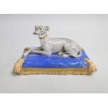 A Staffordshire porcelain model of a Whippet on a blue oblong cushion and tasselled base Date: circa