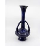 A Bretby Art Pottery triple handled blue drip glaze vase, in the manner of Christopher Dresser, No.