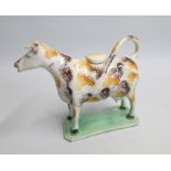 A  Yorkshire Cow Creamer and cover with an ochre and  brown sponged decoration. Date: circa 1790