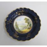 A Royal Worcester Plate with a deep Blue and gilt ground border and scalloped rim. The centre