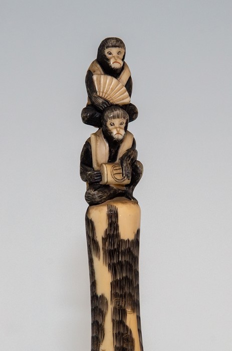 A Japanese ivory tusk carving, Meiji period, 1868-1912, carved as a bearded man playing a flute with - Image 2 of 2