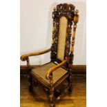 A 19th Century and later walnut Carolean design armchair, carving of a peacock and foliate top on