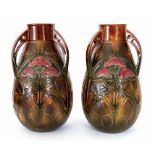 A pair of Bretby Art Pottery tri-handled vases with moulded decoration in the arts and crafts