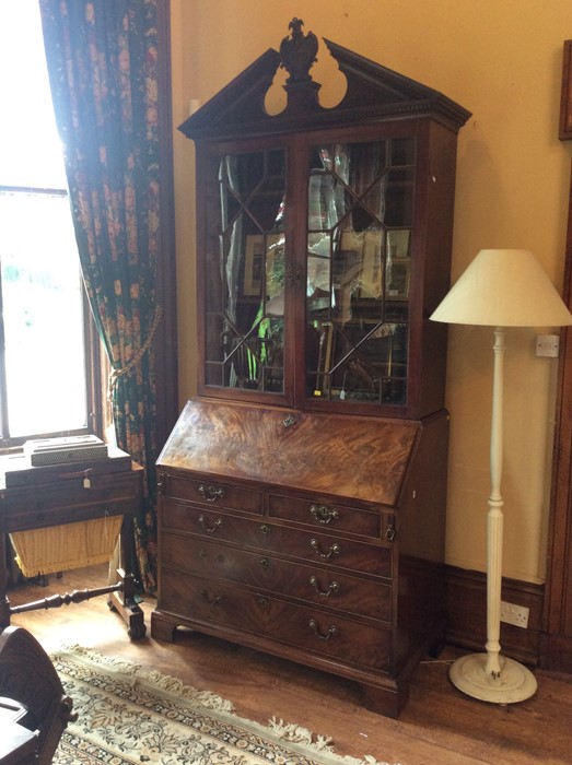 A George III mahogany glazed bookcase bureau, circa 1770, in the manner of Chippendale, crowned with