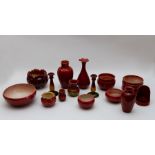 A group of Bretby art pottery red sang de boeuf glazed bowls, jardinieres, vases, candlle sticks and