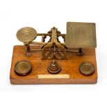 An Edwardian set of brass Sampson Mordan & Co postal scales, with six graduated brass weights on
