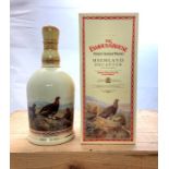 A bottle of Famous Grouse Scotch Blended Whisky in The Famous Grouse Highland Decanter by Wade.