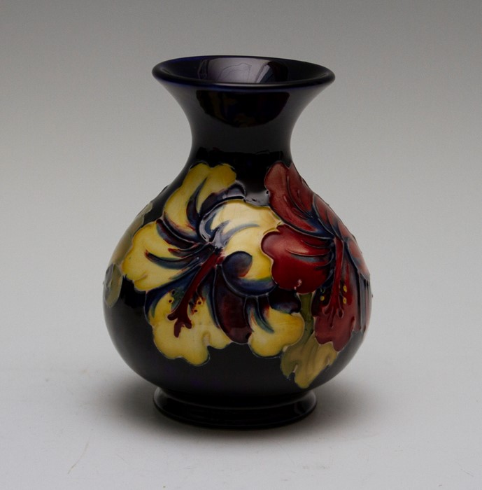 A Moorcroft hibiscus small baluster vase, impressed marks and Moorcroft paper label, height 13cm