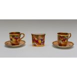 A pair of Royal Worcester painted fruit coffee cups and saucers, gilt interiors, the exteriors